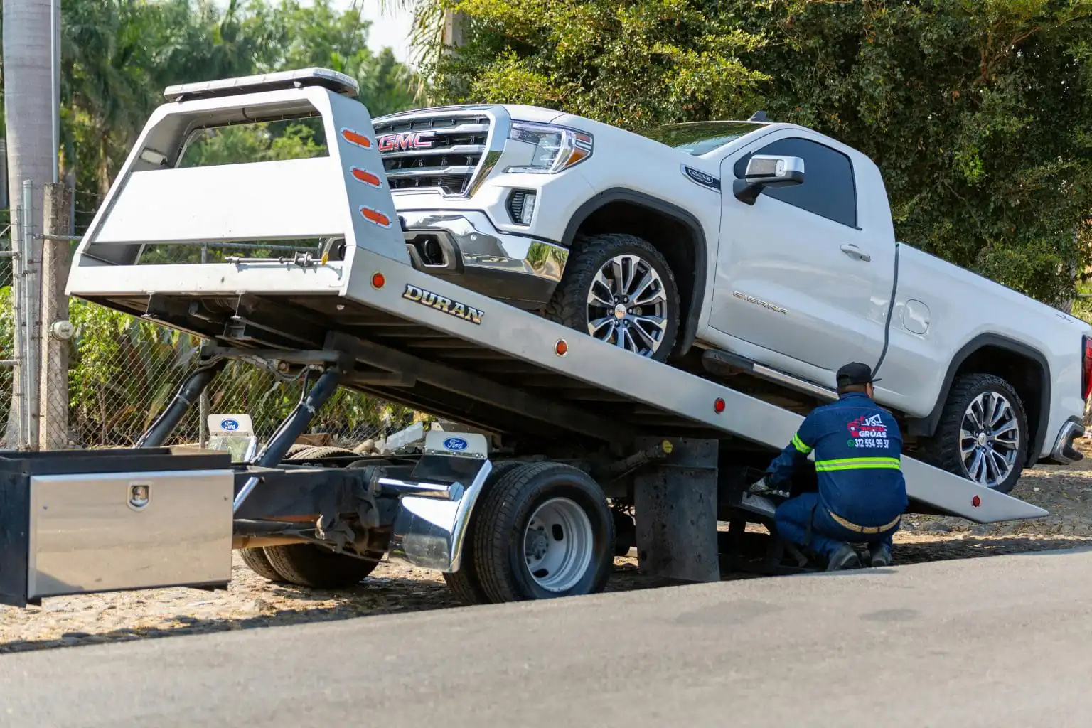 o remorca tip platforma pentru Asistenta rutiera care preia un autoturism de teren marca GMC defect